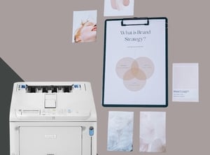 Compact OKI A4 colour printer with printed brand strategy documents and photos