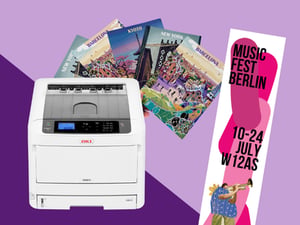 OKI C800 series A3 colour printer with printed city posters and a music festival banner