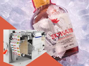 OKI PLAVI ES9542R label press beside a bottle of spirits on ice with a printed label